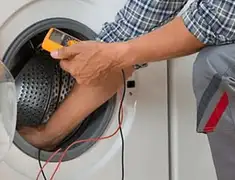 Washing machine repair technician testing a front-load washer with diagnostic tools in Colorado Springs, CO